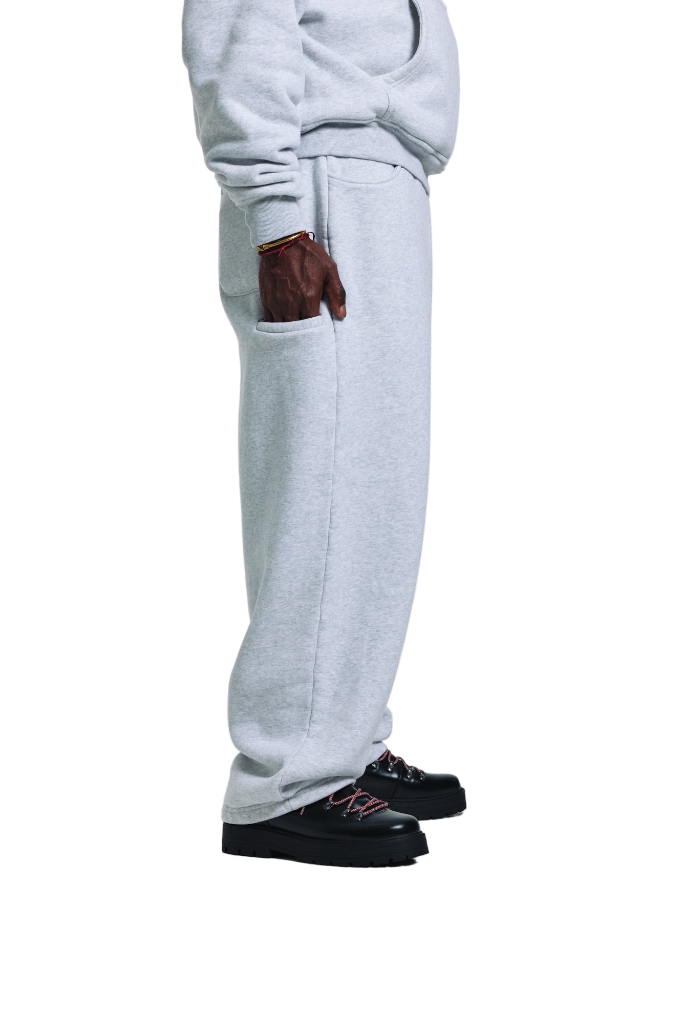 Person wearing gray sweatpants and black shoes on a white background